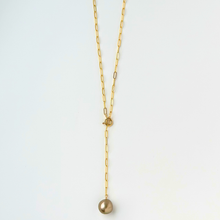 Load image into Gallery viewer, Gold necklace with a single pearl pendant on a light gray background